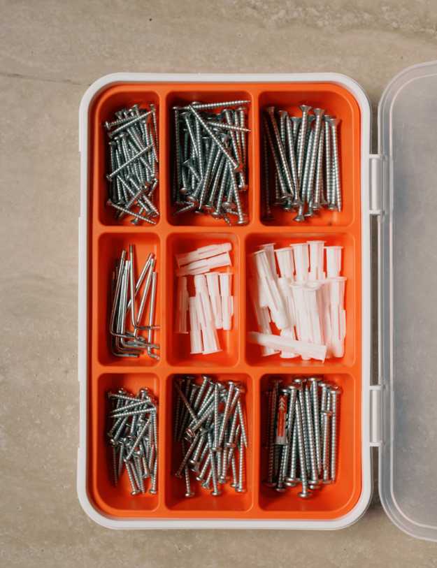 An organized container filled with screws and drywall anchors.
