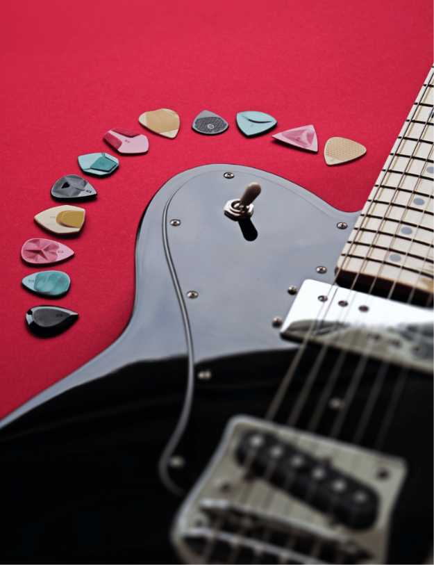 A guitar with guitar picks surrounding it.
